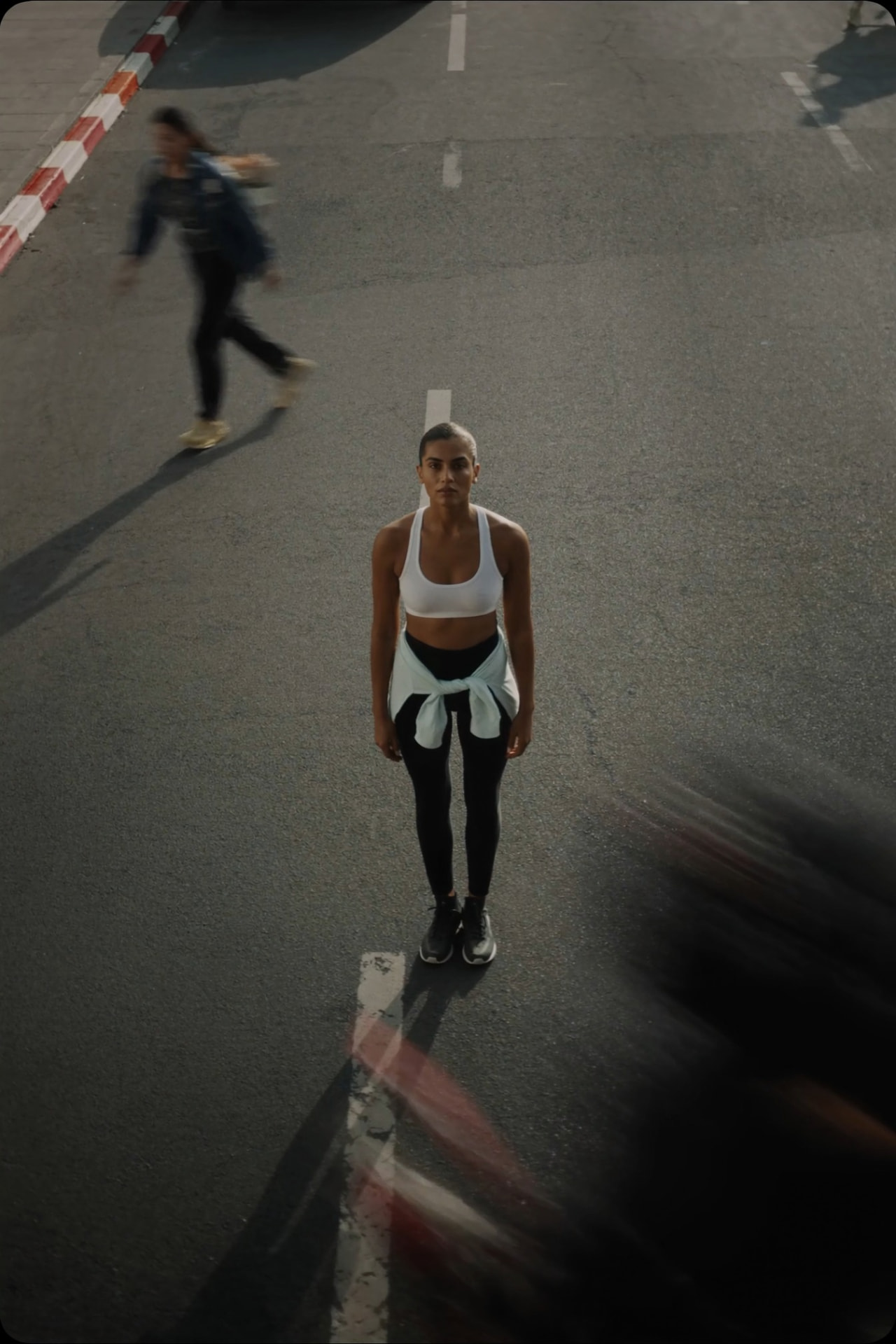 Athlete pausing during an urban street workout, standing strong in the middle of the road